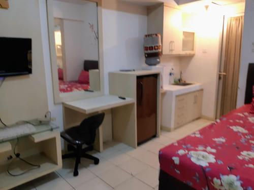 - une chambre avec un lit, un bureau et un miroir dans l'établissement Margonda residence 1& 2 by andrew, à Pondokcina