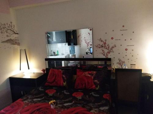 - une chambre avec un lit doté d'oreillers rouges dans l'établissement Margonda residence 1& 2 by andrew, à Pondokcina