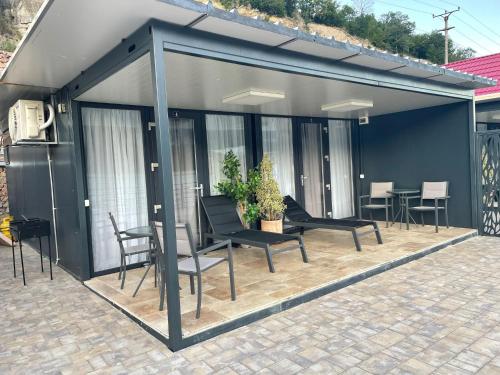 a screened in patio with chairs and a table at Complex Turistic Emilio in Sviniţa