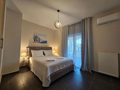 a bedroom with a bed and a large window at Viggas Relaxation Nafpaktos in Antirrio