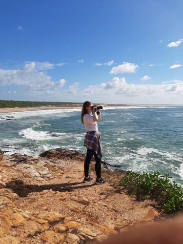 a woman taking a picture of the ocean with a camera at Bundala Flamingo Cotteges in Hambantota