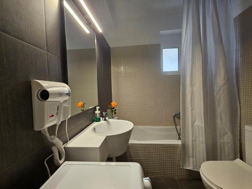uma casa de banho com um lavatório, um WC e uma banheira em Viggas Relaxation Nafpaktos em Antirrio
