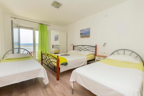 2 letti in una camera con vista sull'oceano di Apartments Vanesa a Dugi Rat (Punta Lunga)