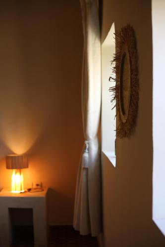 a room with a table and a lamp and a mirror at Kasbah des cyprès in Skoura