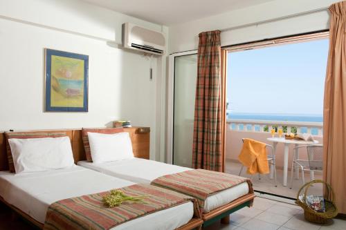 a hotel room with a bed and a balcony at Andromeda Apartments & Studios in Hersonissos