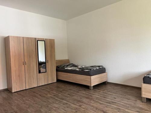 a room with two beds and a wooden cabinet at Wiehengebirgs Fernblick App 3 in Bad Essen