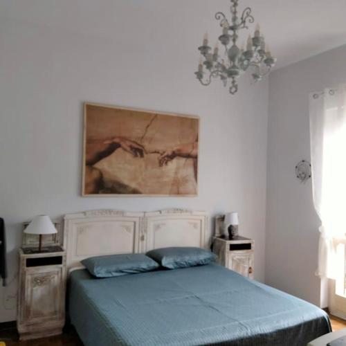 a bedroom with a bed with a painting on the wall at Appartamento Giglio in Stropino