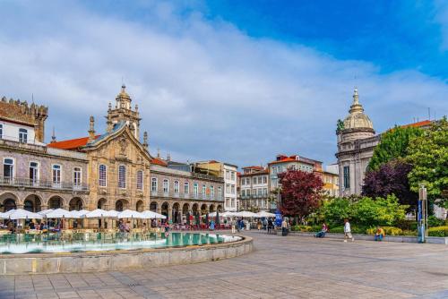 a city square with a fountain in front of a building at Station House in Braga