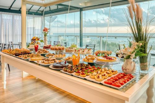 ein Buffet mit Speisen auf einem langen Tisch in der Unterkunft Hotel Augustus in Rimini
