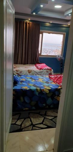 um pequeno quarto com 2 camas e uma janela em الاسكندريه em Alexandria