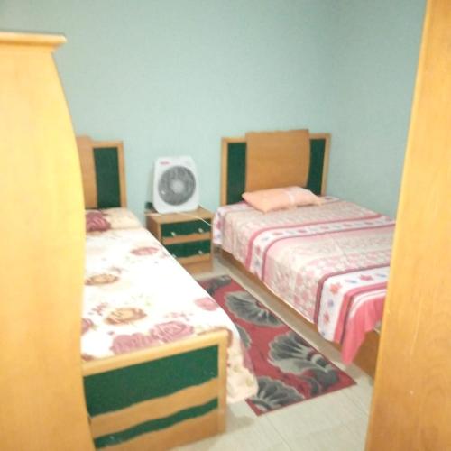 um quarto com 2 camas e uma ventoinha em الاسكندريه em Alexandria