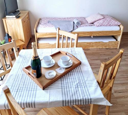 een kamer met een tafel met een fles wijn en een dienblad bij Apartmán H&H na Vysočině in Střítež