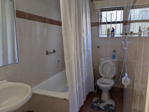 a bathroom with a toilet and a tub and a sink at Westlands bliss haven paradise fully furnished 1bedroom apartments 