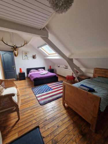 a attic room with a bed and a couch at B&B Le Moulin de Fernelmont in Forville