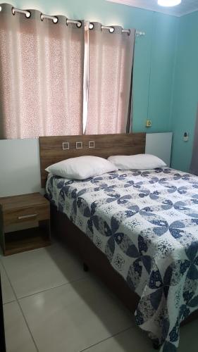 1 dormitorio con 1 cama con edredón azul y blanco en Casa de 2 quartos no Centro de Bombinhas, en Bombinhas