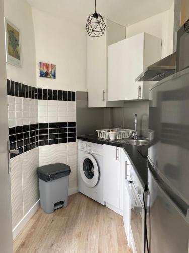 a kitchen with a washing machine and a sink at Studio de charme in Pantin