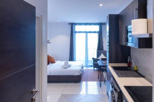 a bedroom with a bed and a kitchen with a sink at Exec. Studio @Embassy Gardens in Cantonments