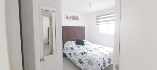 um quarto branco com uma cama e um espelho em Departamento-Poliforum Feria Estadio Zona Piel. em León