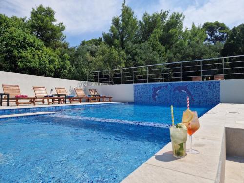 a swimming pool with chairs next to a swimming pool at Villa Olivila in Dubrovnik
