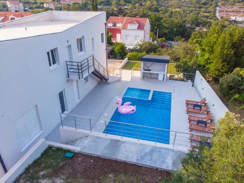 杜布羅夫尼克的住宿－Villa Olivila，一座带粉红色火烈鸟游泳池的房子