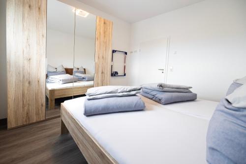 een slaapkamer met 2 bedden en een spiegel bij Ferienresidenz Hunsrück Hochwald in Mörschied