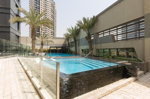 a swimming pool in a building with palm trees at Hostel InterCube in Dubai