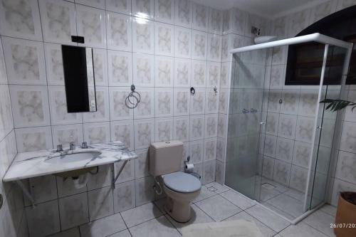 a bathroom with a toilet and a sink and a shower at Oberon in Curitiba