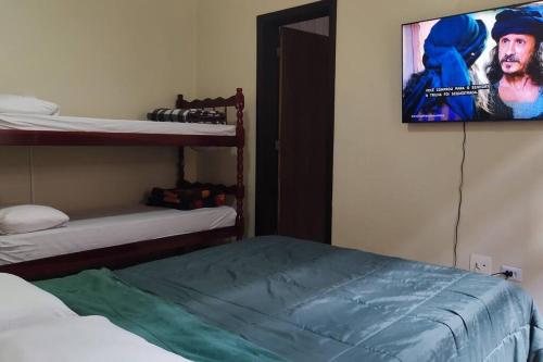 a room with two bunk beds and a tv on the wall at Oberon in Curitiba