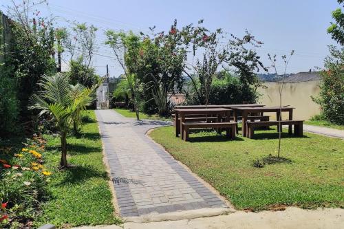 dos bancos y una mesa en un jardín en Oberon, en Curitiba