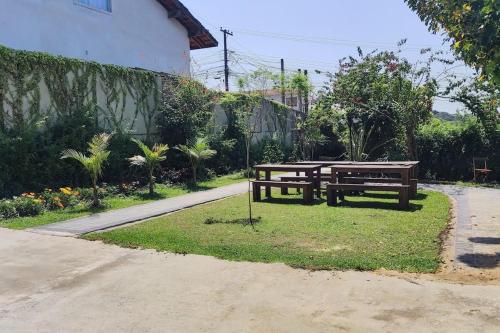two benches and a picnic table in a garden at Oberon in Curitiba