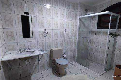 a bathroom with a toilet and a sink and a shower at Oberon in Curitiba