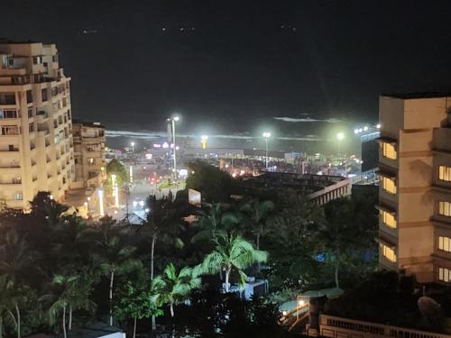 een stad 's nachts met gebouwen en palmbomen bij Sea doll 7th floor with Sea view in Visakhapatnam