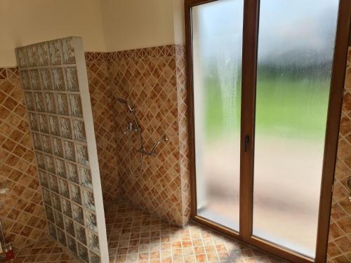 a shower with a glass door in a bathroom at Pensiunea Eden Éden Panzió in Odorheiu Secuiesc