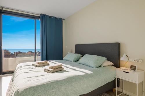 Schlafzimmer mit einem Bett und einem großen Fenster in der Unterkunft Star View in Fuengirola