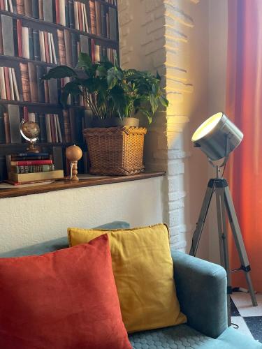 a living room with a blue couch with two pillows at Le Trouville - Hôtel de Charme in Trouville-sur-Mer