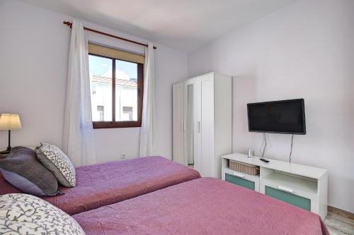 1 dormitorio con 2 camas, TV y ventana en CRISTINA´S HISTORICAL VIEWS, en Santa Cruz de la Palma