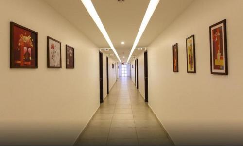 a hallway of a building with paintings on the walls at Hotel Luciya Palace in Trichūr