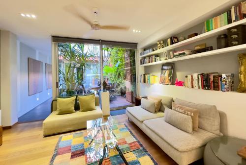 a living room with two couches and a glass table at ArtlifeBCN Urban Oasis Apartment in Barcelona