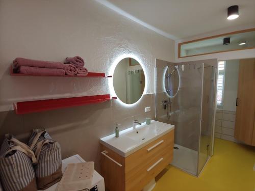 uma casa de banho com um lavatório, um chuveiro e um espelho. em Ferienhaus zur Opernsängerin em Hartberg