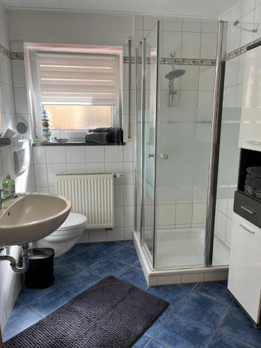 a bathroom with a shower and a toilet and a sink at Ferienwohnung Mara in Ettringen