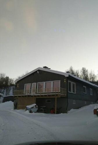 a large building with a balcony in the snow at Hele utleiebolig Årøybuktneset in Lyngseidet