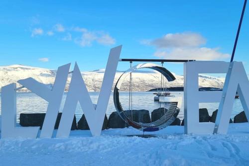 a sign in the snow with a swing at Hele utleiebolig Årøybuktneset in Lyngseidet