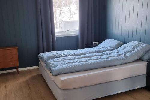 a bed sitting in a room with a window at Hele utleiebolig Årøybuktneset in Lyngseidet