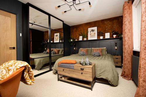 een slaapkamer met een bed en een grote spiegel bij The Longsands Home- Coastal Retreat with Hot Tub in Cullercoats