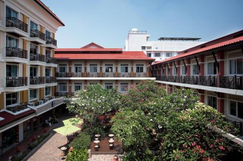 un complejo de apartamentos con un patio con árboles y edificios en Rambuttri Village Plaza - SHA Extra Plus en Bangkok