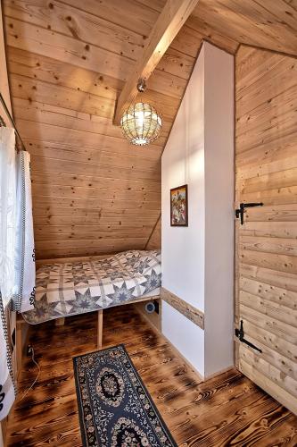 a small room with a bed in a log cabin at Prawie na końcu drogi in Rabka-Zdroj