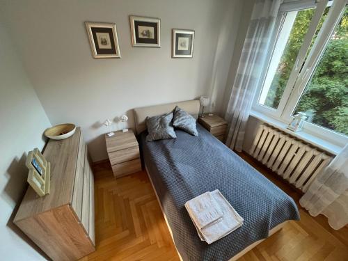 a small bedroom with a bed and a window at Apartament Elizabeth in Gdynia