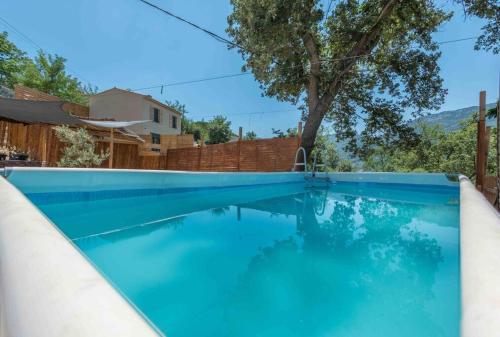 una piscina con acqua blu in un cortile di Aux Studio sous les oliviers Netflix et Disney plus a Contes