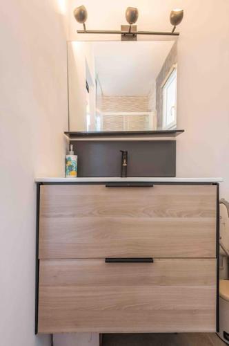 - une commode avec un miroir et un tiroir en bois dans l'établissement Aux Studio sous les oliviers Netflix et Disney plus, à Contes