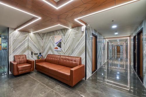 a lobby with a brown leather couch in a building at The Scenic Unity in Garudeshwar
